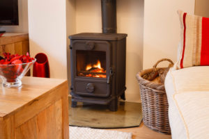 black wood stove with basket of wood